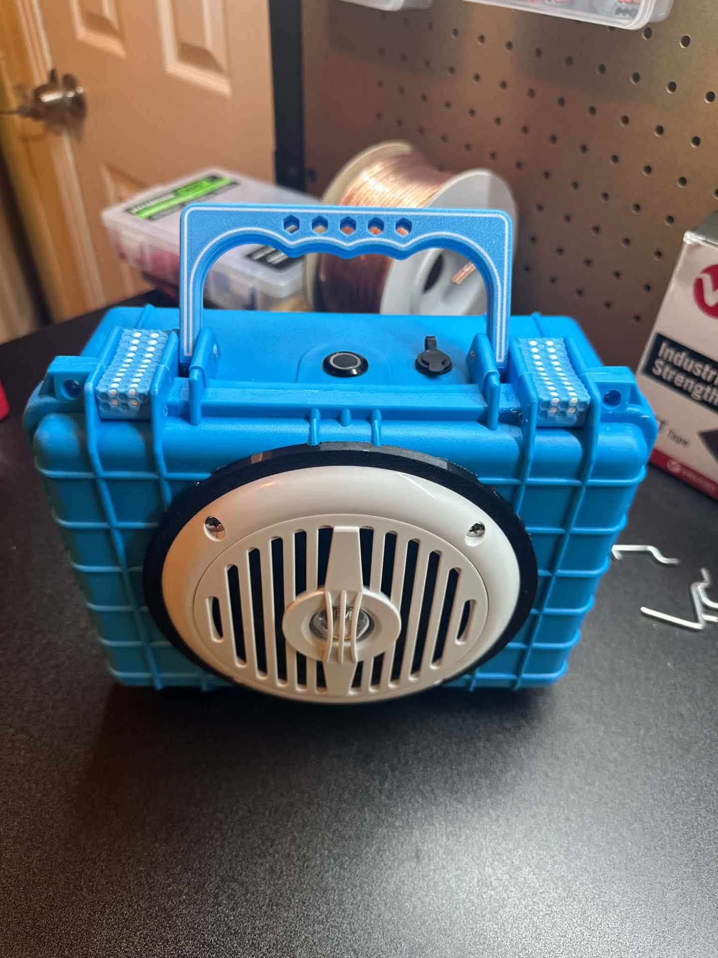 Bright blue rugged custom speaker with white oval grille and blue handle